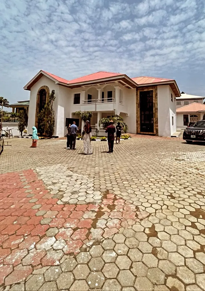 Clients viewing a completed white residence from its interlocked forecourt