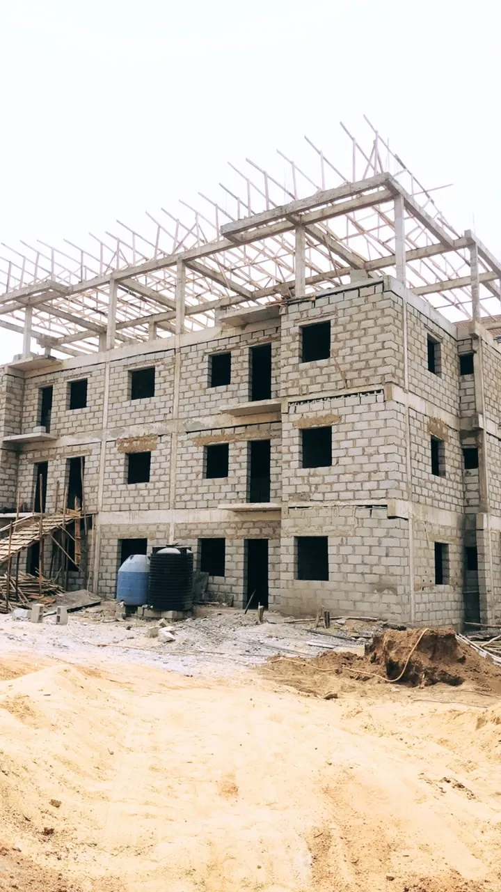 Three-storey block building with its roof structure going on